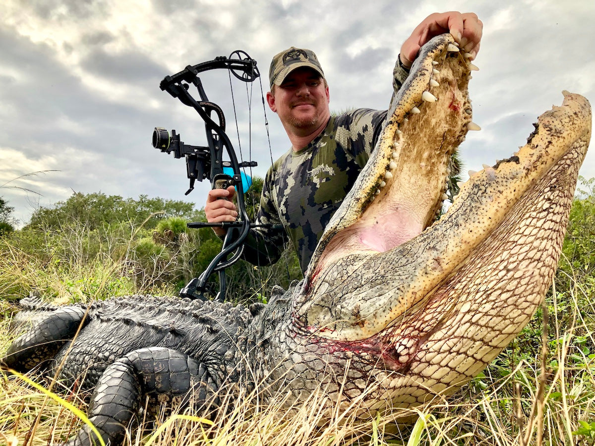 Man posing with gator he caught on a Florida Alligator Hunt. 